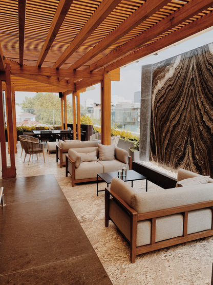 Outdoor patio with wooden pergola, furniture, and a cityscape view.